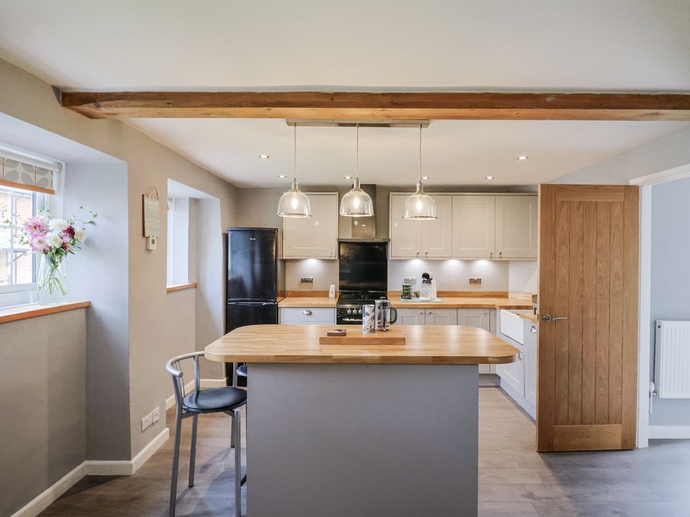 A kitchen with an island and cabinets at Rushmoor Cottage in Colaton Raleigh