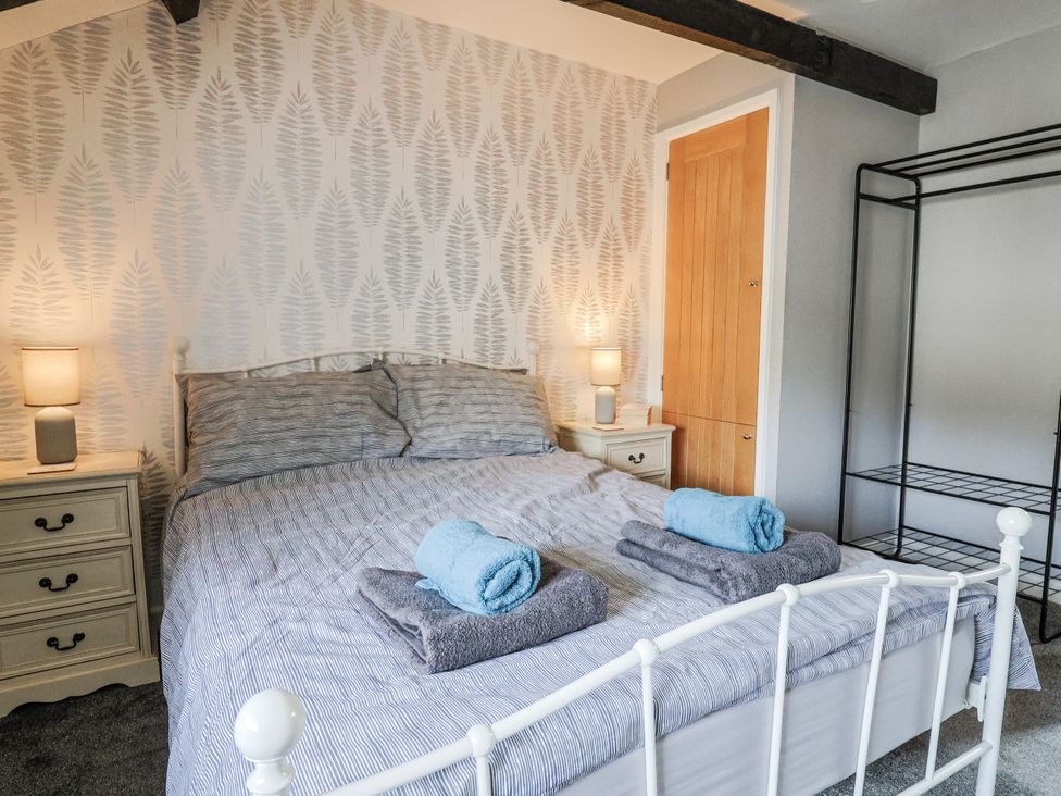 A bedroom with a bed and bedside table at Rushmoor Cottage in Colaton Raleigh