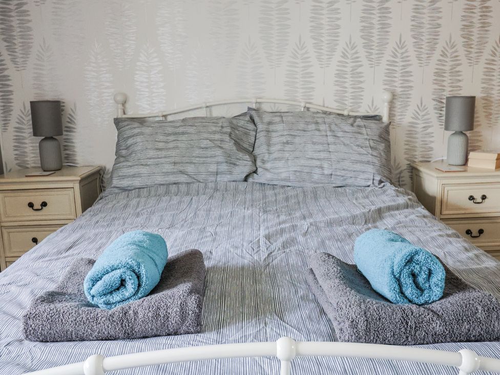 A bedroom with a bed and bedside tables at Rushmoor Cottage in Colaton Raleigh