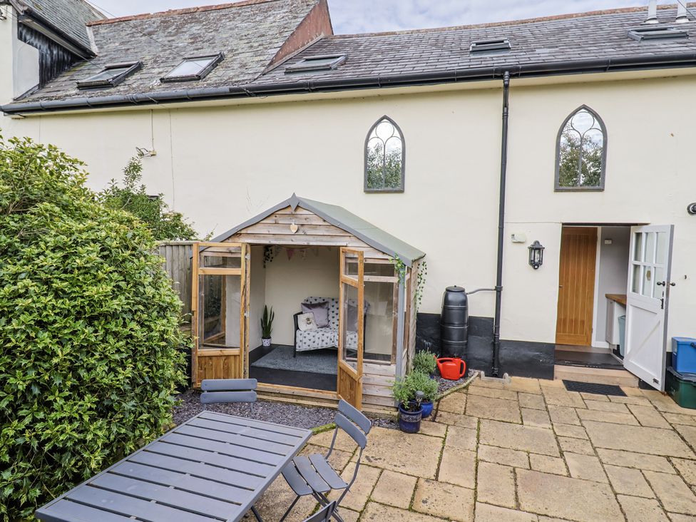 A garden with a shed and outdoor furniture at Rushmoor Cottage in Colaton Raleigh