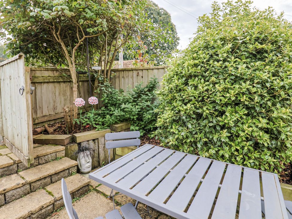 A garden with a table and chairs at Rushmoor Cottage in Colaton Raleigh