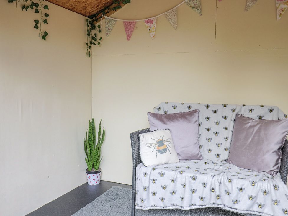 A snug with a sofa and plant in Rushmoor Cottage Colaton Raleigh