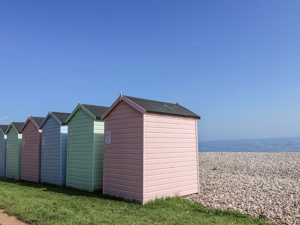 A row of beach huts near the ocean at Rushmoor Cottage in Colaton Raleigh