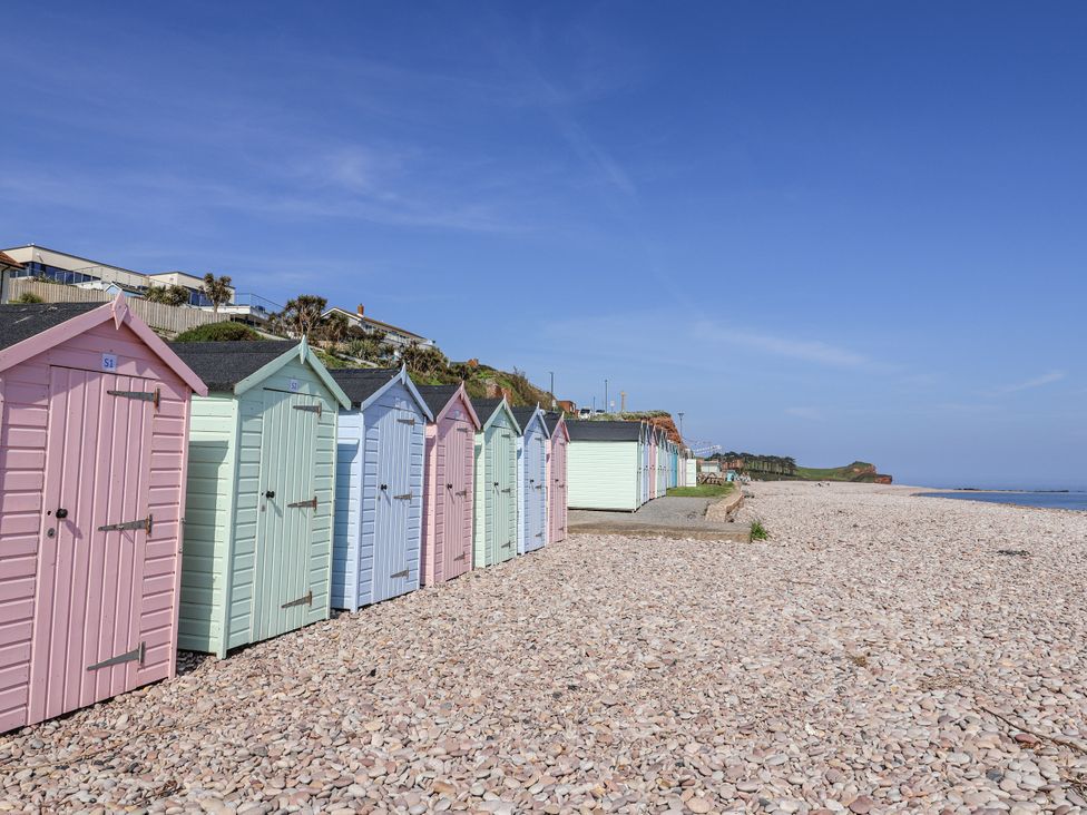 A row of beach huts on a pebble beach at Rushmoor Cottage, Colaton Raleigh