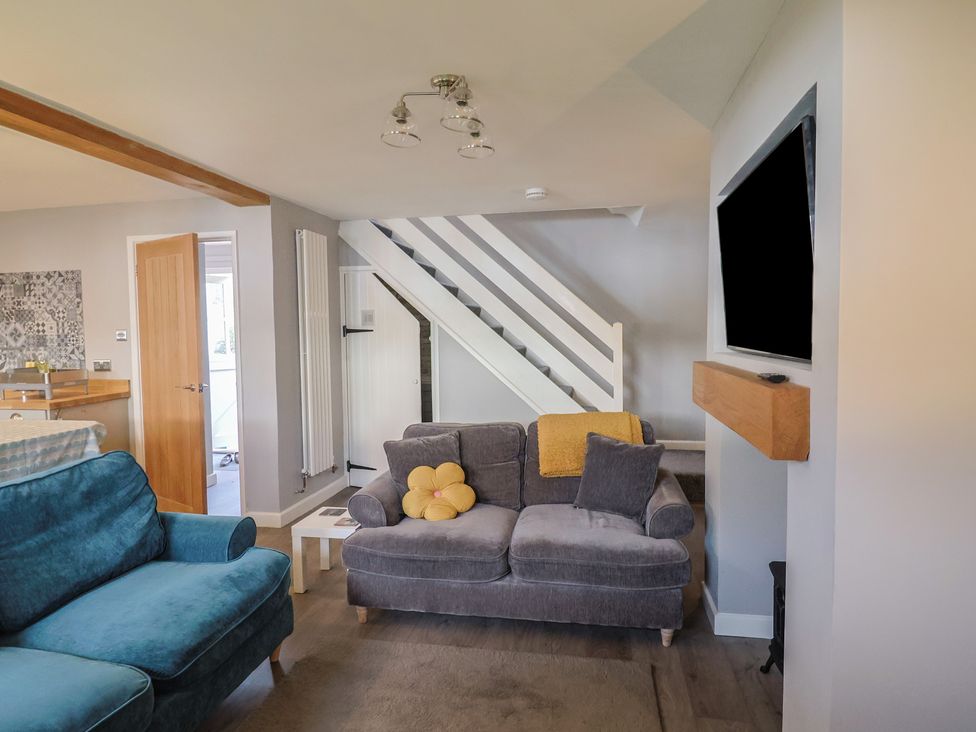 A living room with sofa and television at Rushmoor Cottage in Colaton Raleigh
