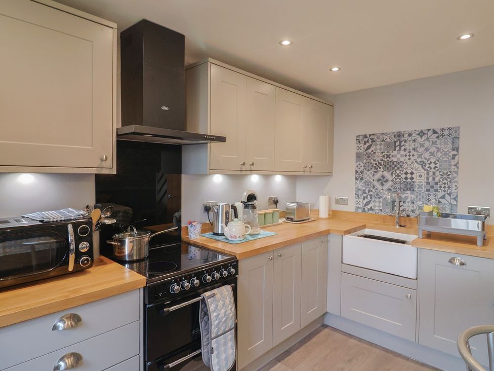 A kitchen with a stove and sink at Rushmoor Cottage in Colaton Raleigh
