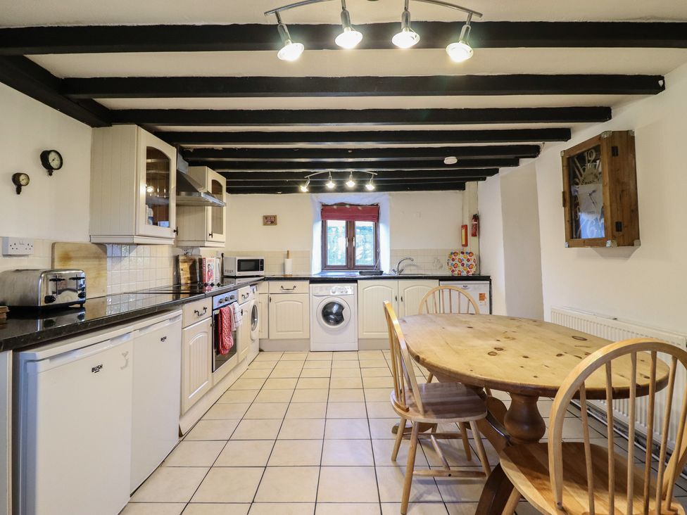 A kitchen with a table and chairs at 1 Fron Uchaf Parc near Bala