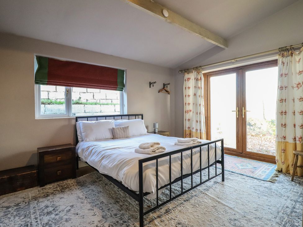 A bedroom with a double bed and wooden door at 1 Fron Uchaf in Parc near Bala