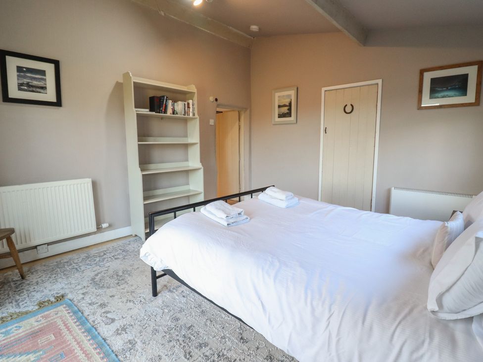 A bedroom with a bed and shelves at 1 Fron Uchaf in Parc near Bala