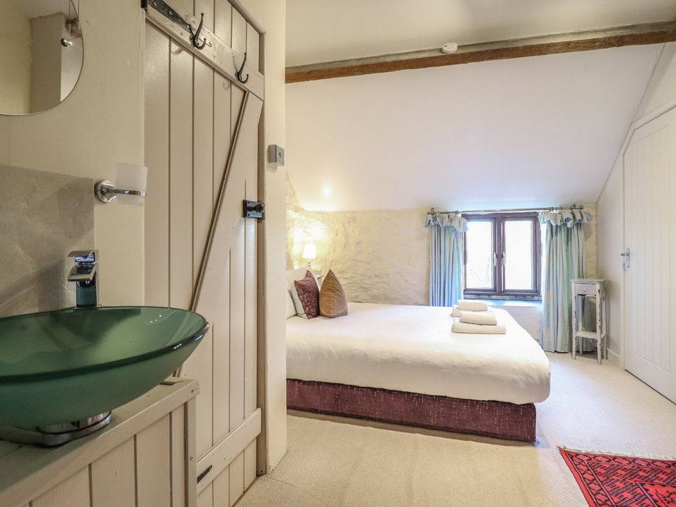 A bedroom with a bed and a sink at 1 Fron Uchaf in Parc near Bala