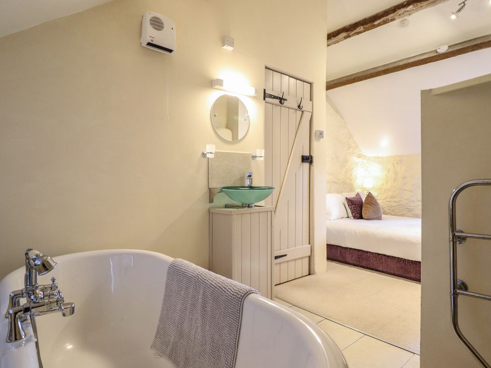 A bathroom with a bathtub and a sink with a mirror at 1 Fron Uchaf in Parc near Bala