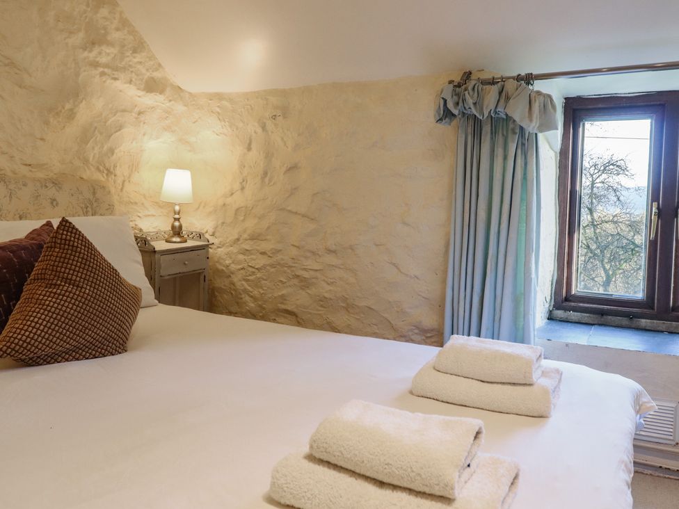 A bedroom with a bed and lamp at 1 Fron Uchaf in Parc near Bala