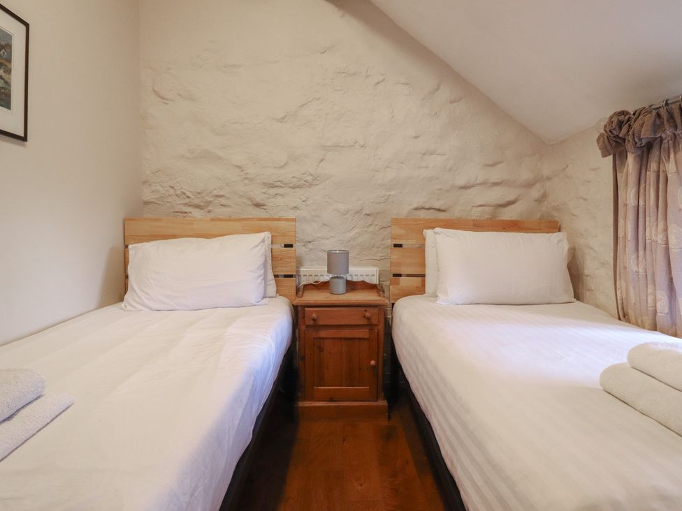 Two single beds with bedside table and lamp at 1 Fron Uchaf Parc near Bala