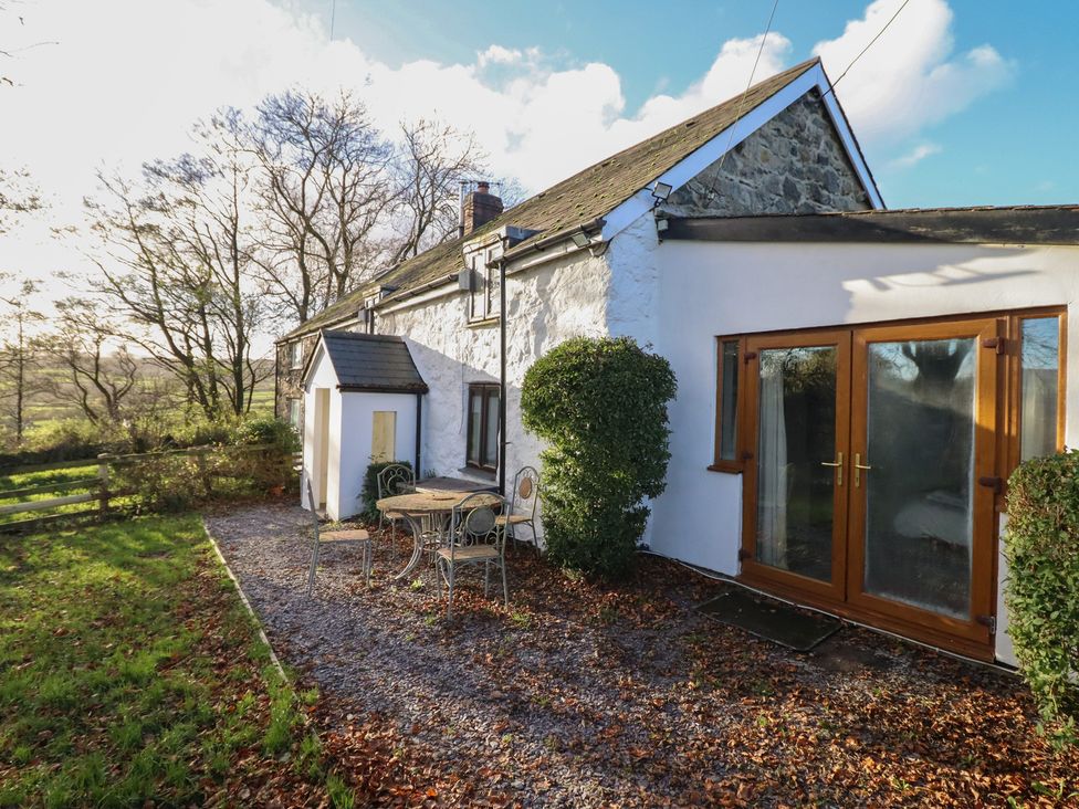 A house with a table and chairs outside at 1 Fron Uchaf in Parc near Bala