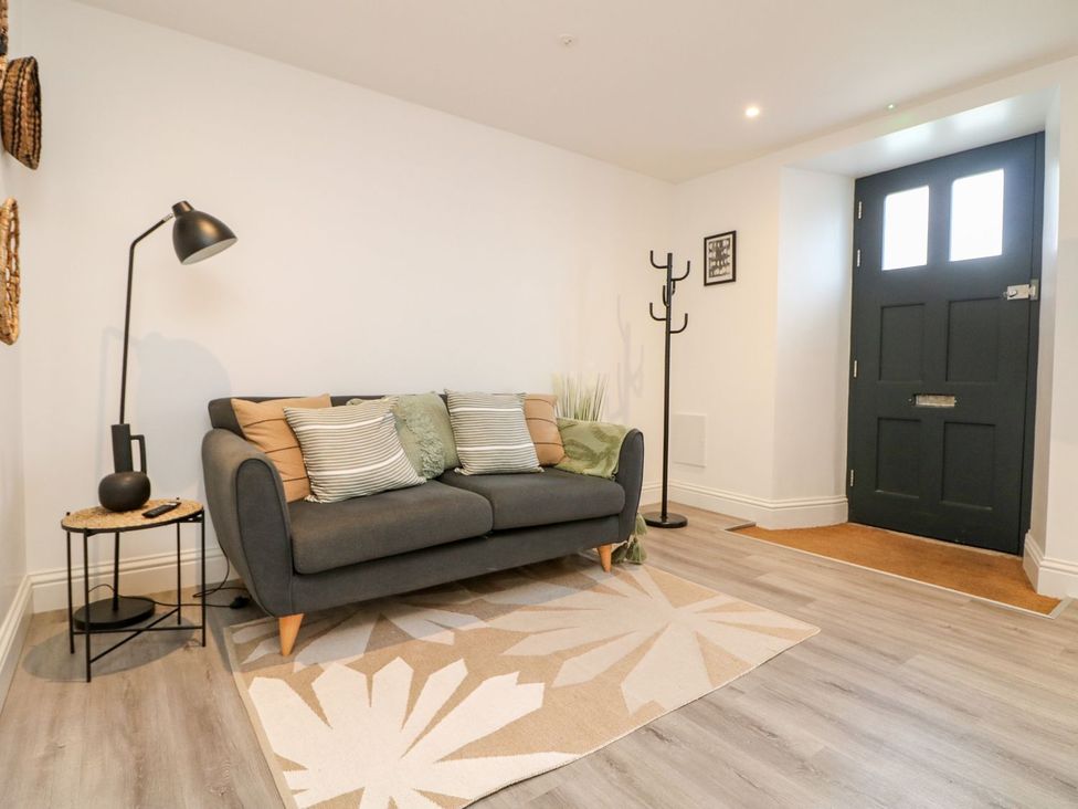 A living room with a sofa and a coat rack at Klysa in Camborne