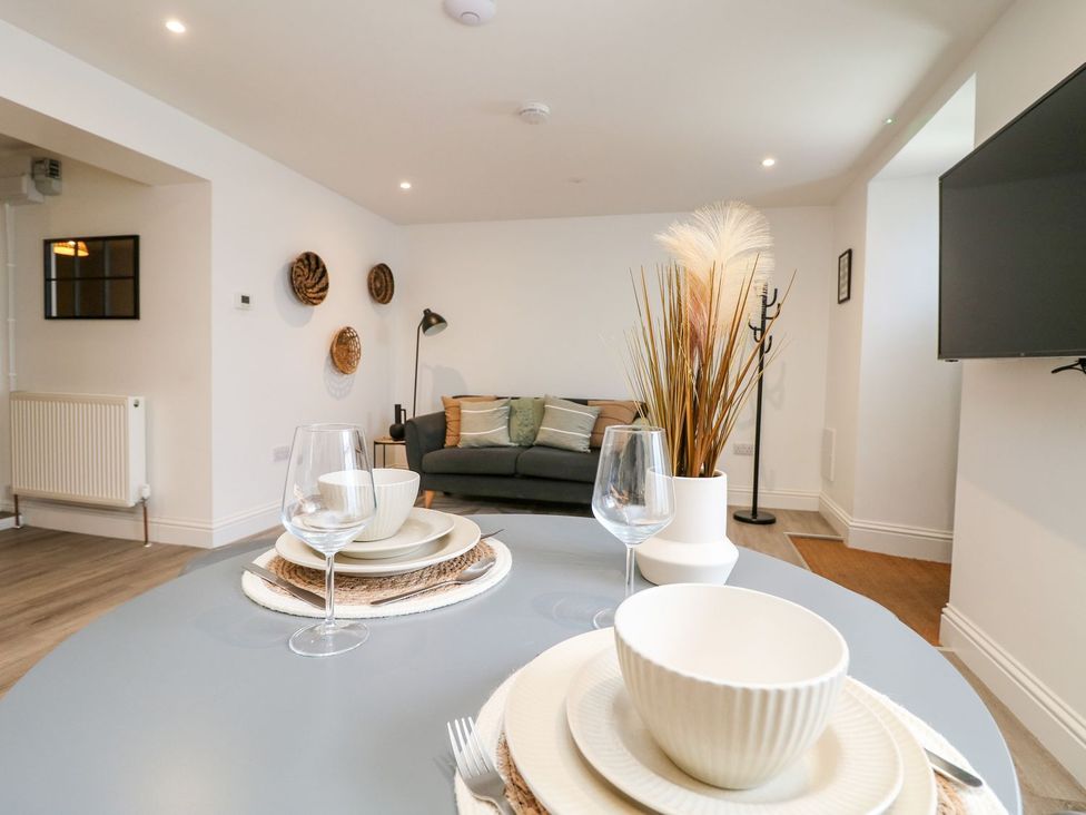 A living room with a sofa and dining table at Klysa in Camborne