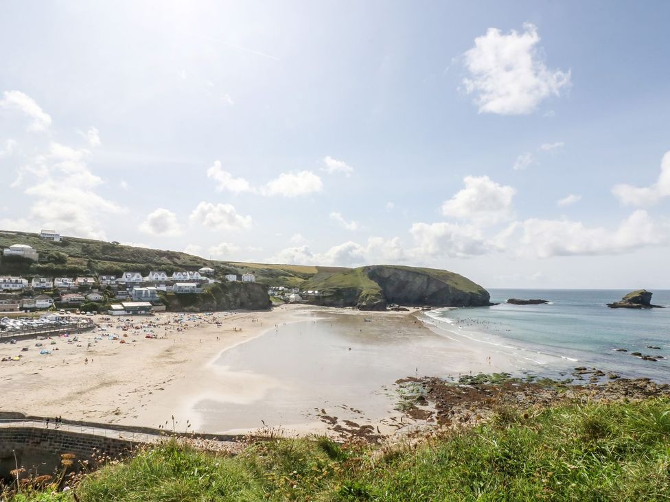 A beach with sand and water at Thomas Chambers in Camborne