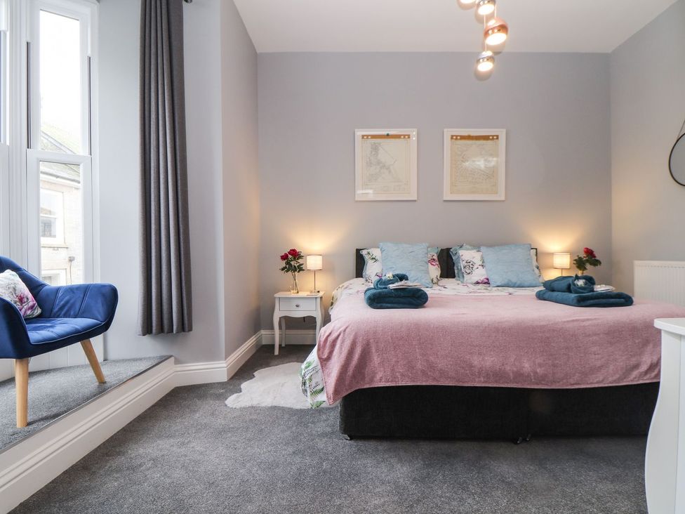 A bedroom with a bed and nightstand at Baker Chambers in Camborne