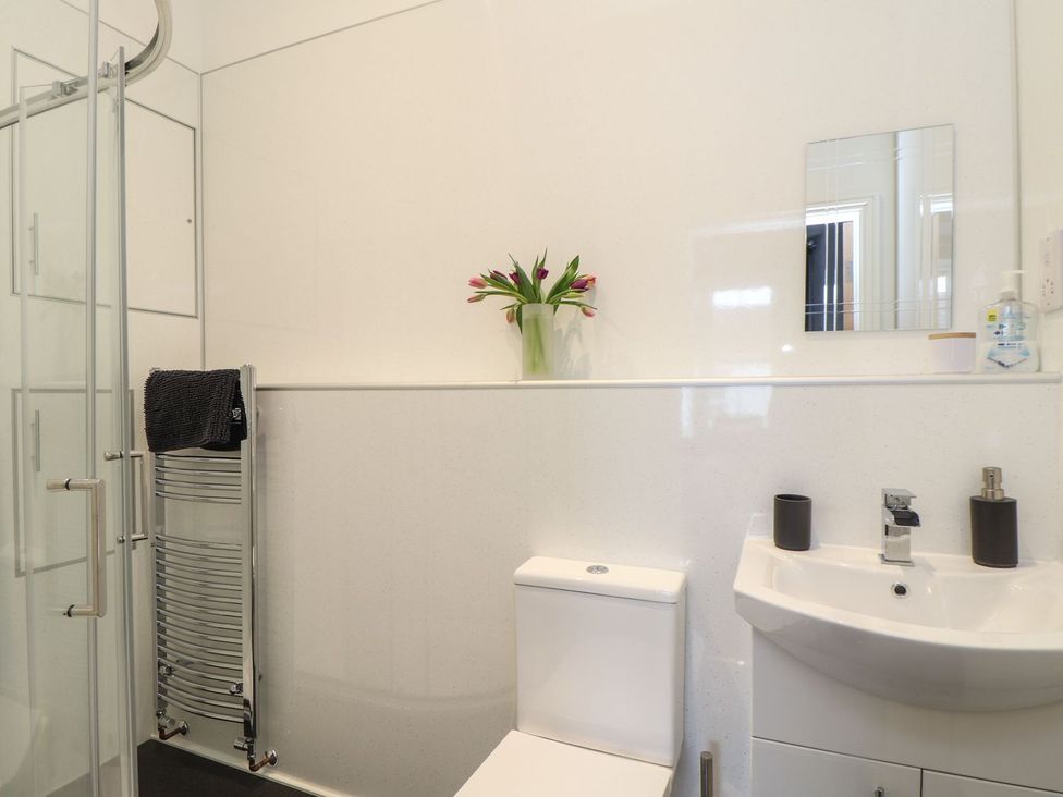 A bathroom with a shower, toilet, and sink at Baker Chambers in Camborne