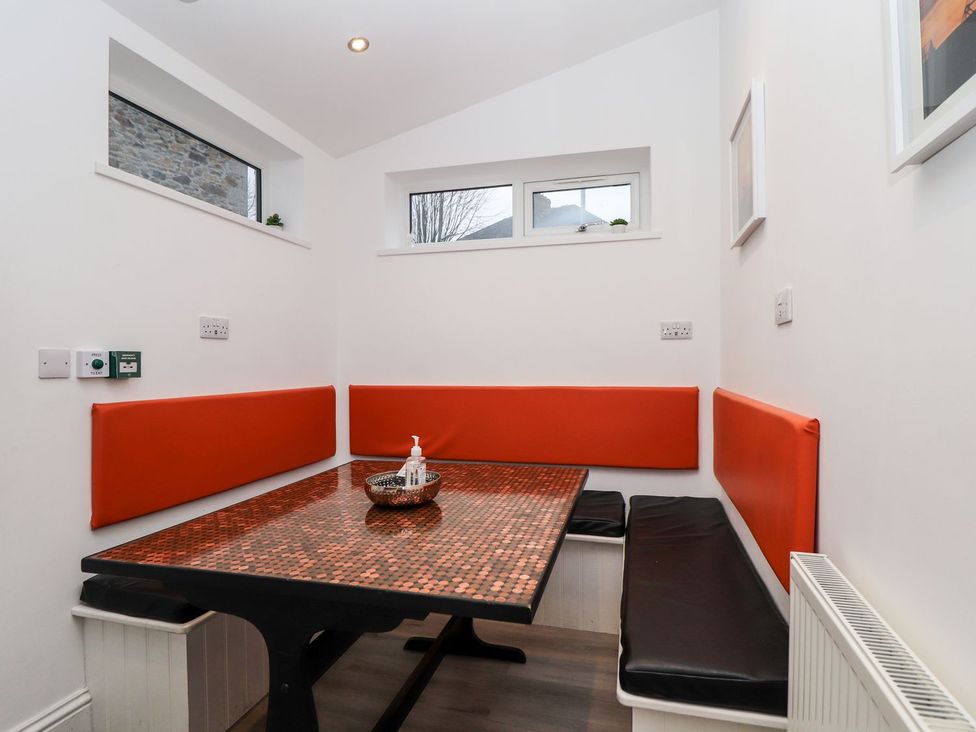A dining area with a table and bench seating at Teylu in Camborne