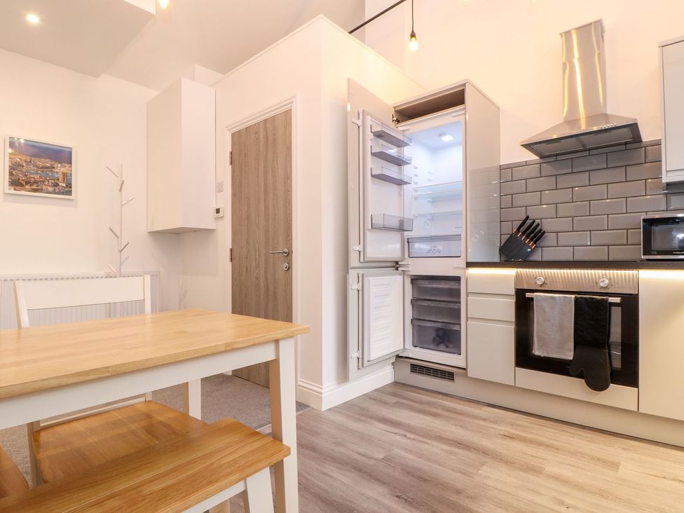 A kitchen with an open refrigerator and a table at Battell Chambers in Camborne