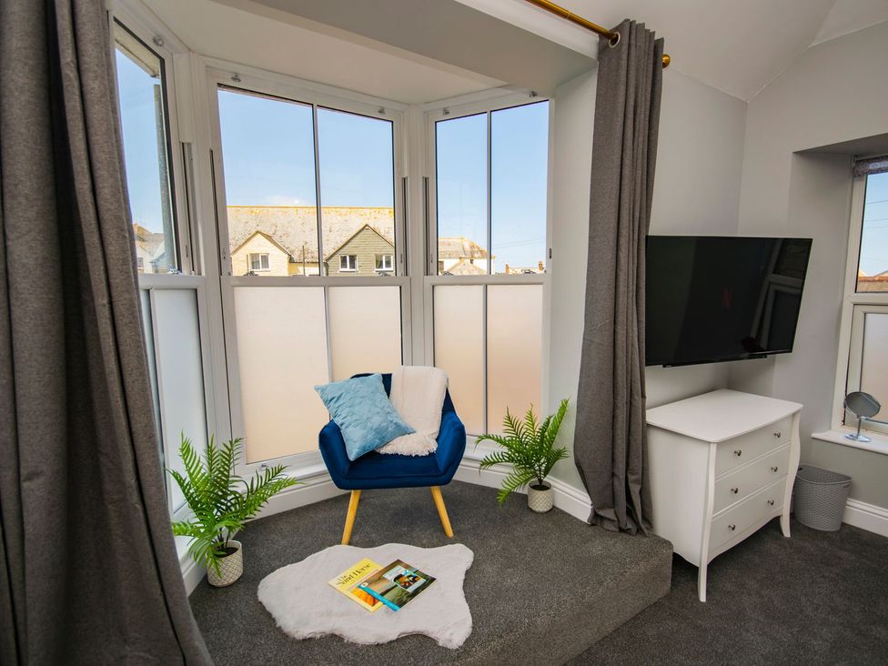 A snug with a chair and television at Daniel Chambers in Camborne