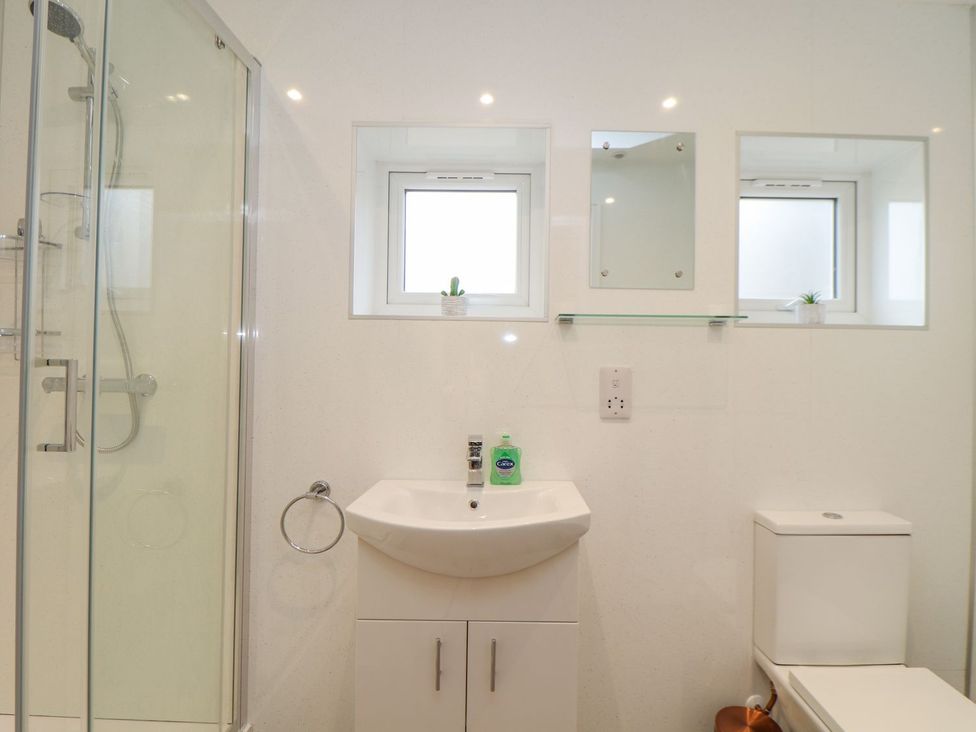 A bathroom with a shower, sink, and toilet at Mews Retreat in Camborne