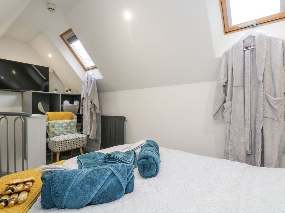 A bedroom with a bed and towels in the corner at The Snug in Camborne