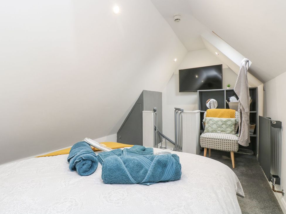 A bedroom with a bed and television at The Snug in Camborne