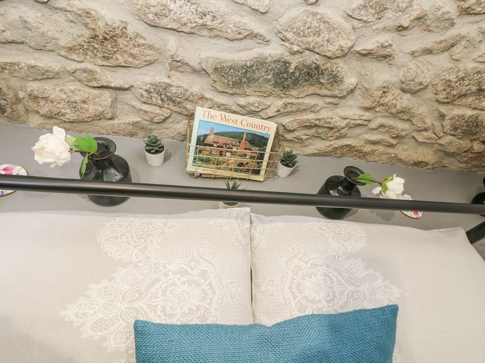 A bedroom with a bed and decorative items at The Snug in Camborne