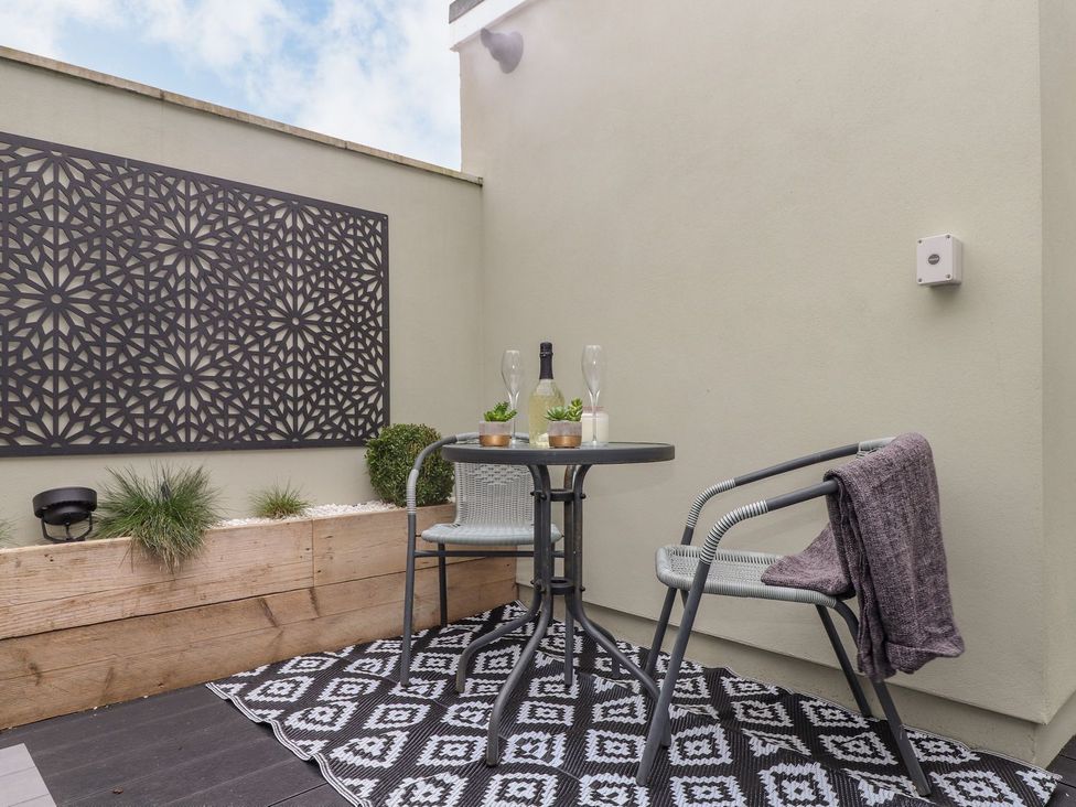 A balcony with a table and chairs at The Snug in Camborne
