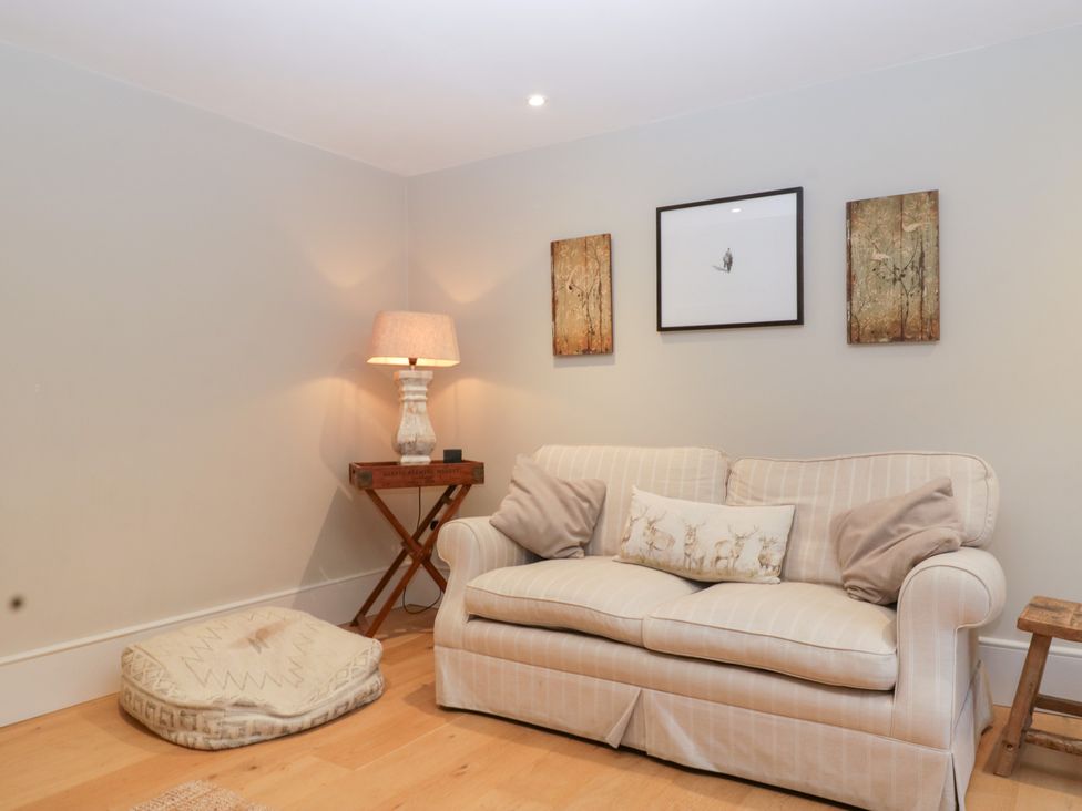 A living room with a sofa and lamp at Spring View in Tetbury