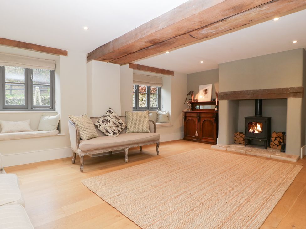 A living room with a sofa and a fireplace at Spring View in Tetbury