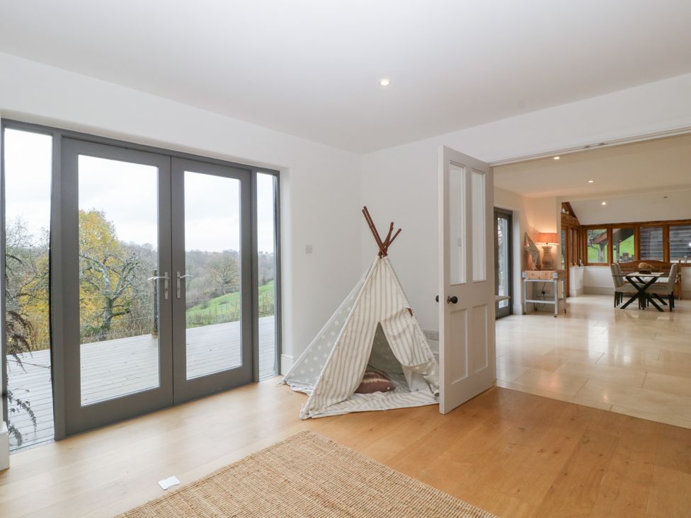 A living room with double doors leading to a deck at Spring View in Tetbury