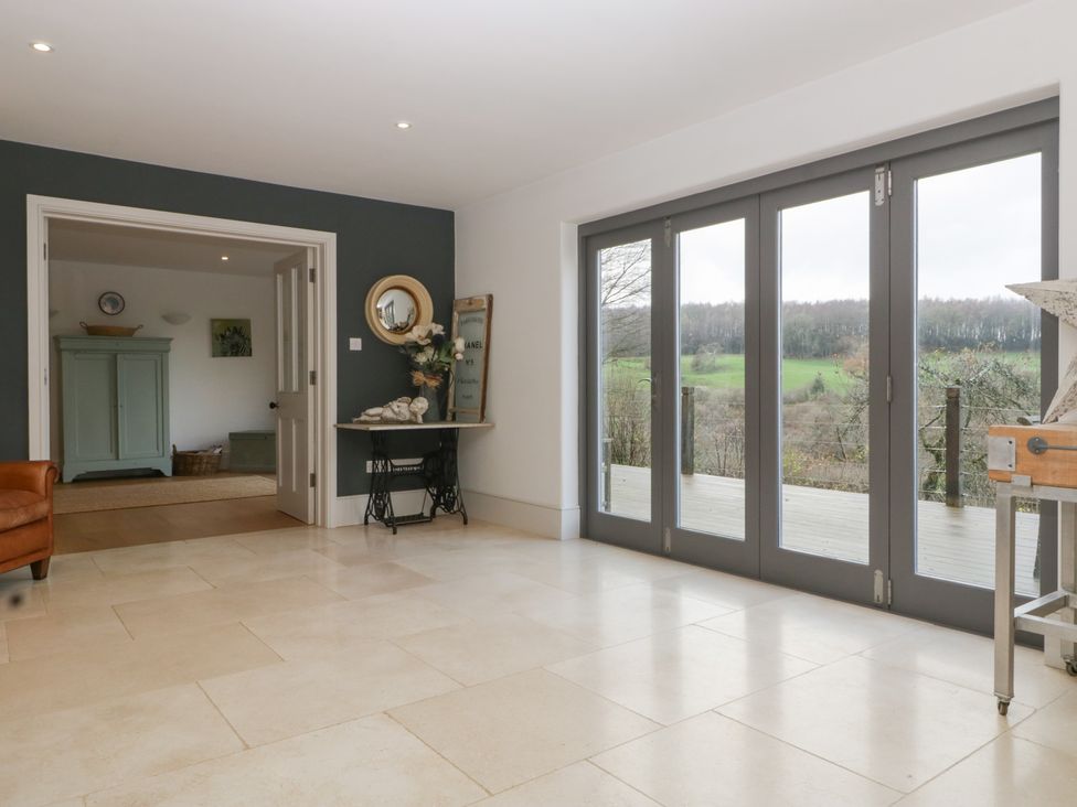A living room with a door and windows at Spring View in Tetbury
