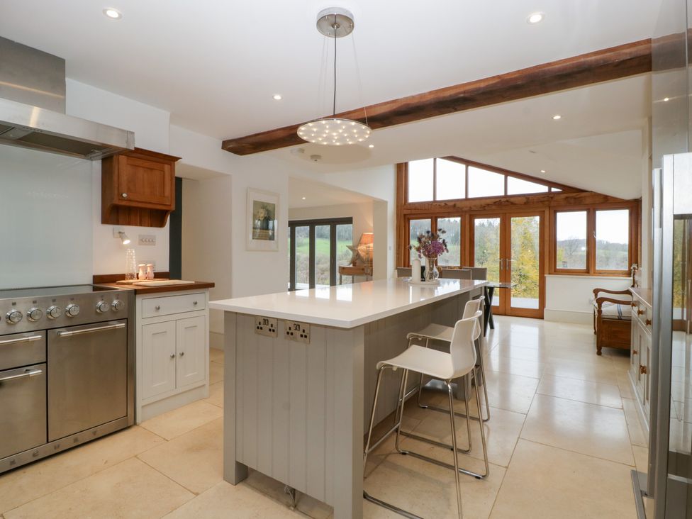 A kitchen with a large island and stove at Spring View in Tetbury