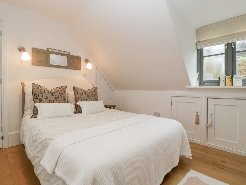 A bedroom with a bed and side table at Spring View in Tetbury