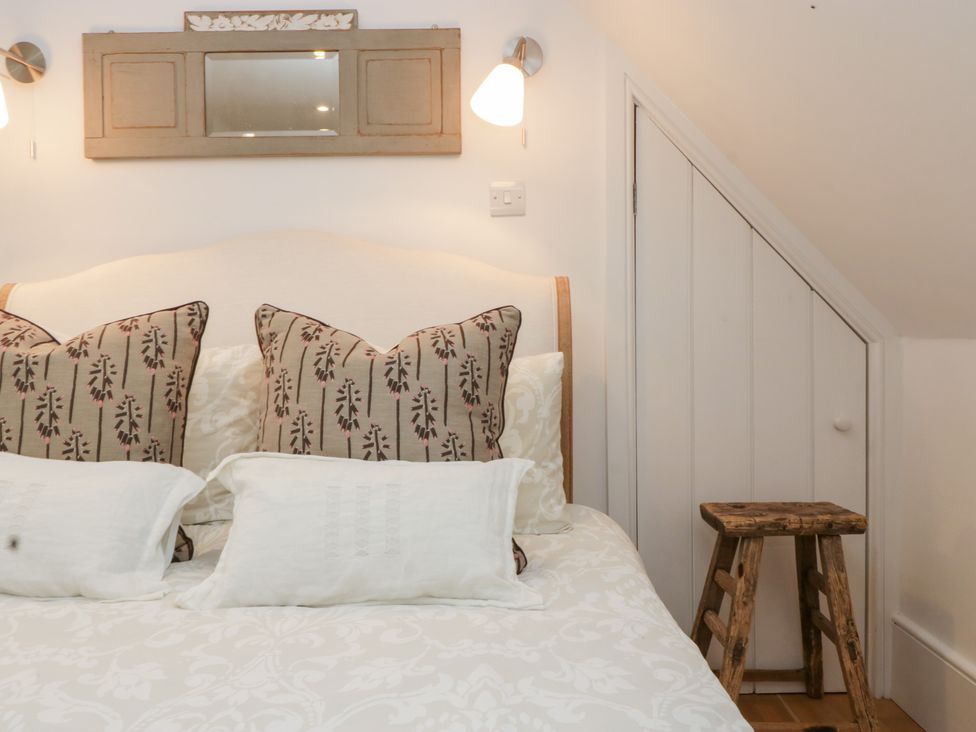 A bedroom with a bed and cushions at Spring View in Tetbury