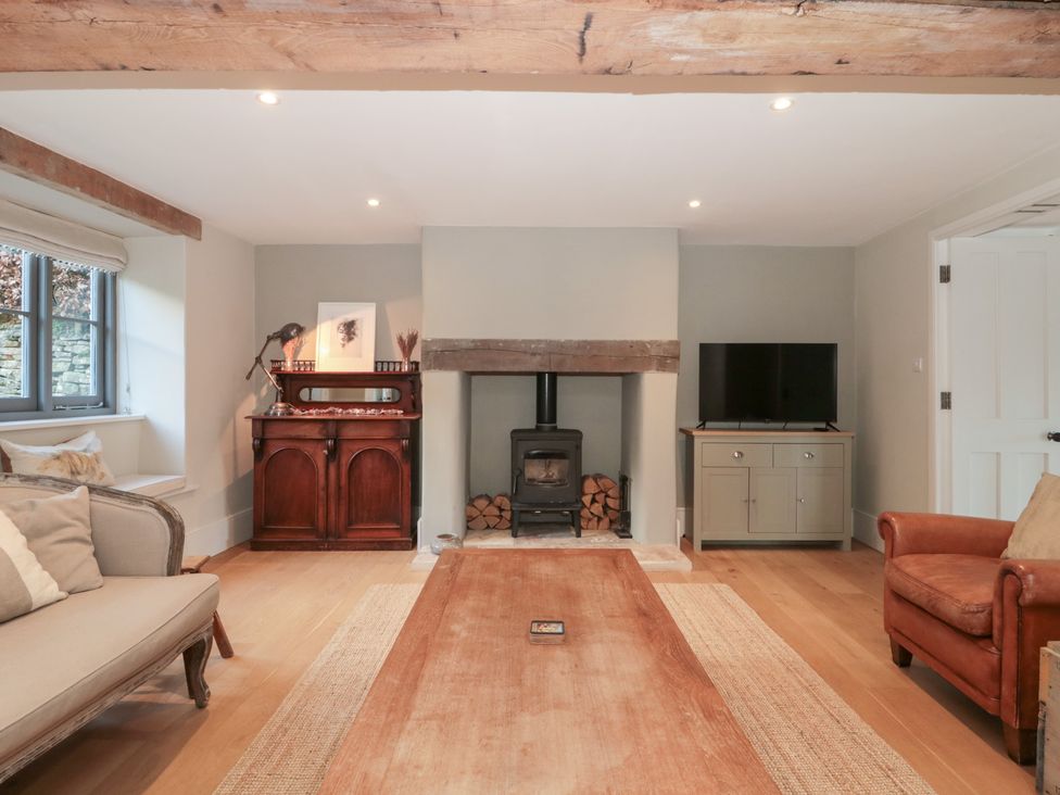 A living room with a fireplace and television at Spring View in Kingscote, Gloucestershire