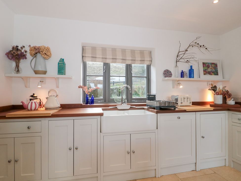 A kitchen with a sink and cabinets at Spring View in Kingscote, Gloucestershire