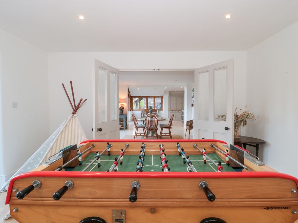 A foosball table with a view into the dining area at Spring View in Kingscote, Gloucestershire