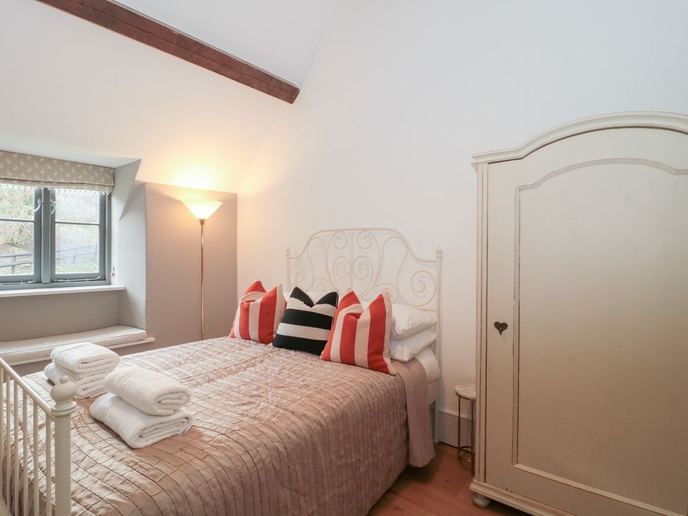 A bedroom with a bed and wardrobe at Spring View in Kingscote, Gloucestershire