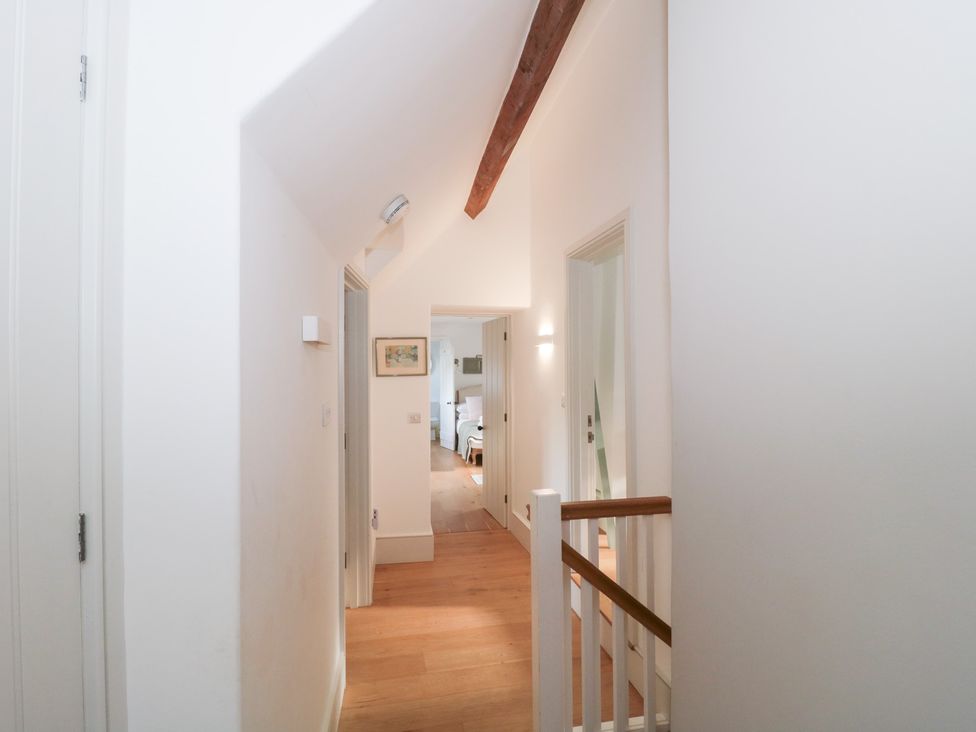 A hallway with doors and a wooden beam at Spring View in Kingscote, Gloucestershire
