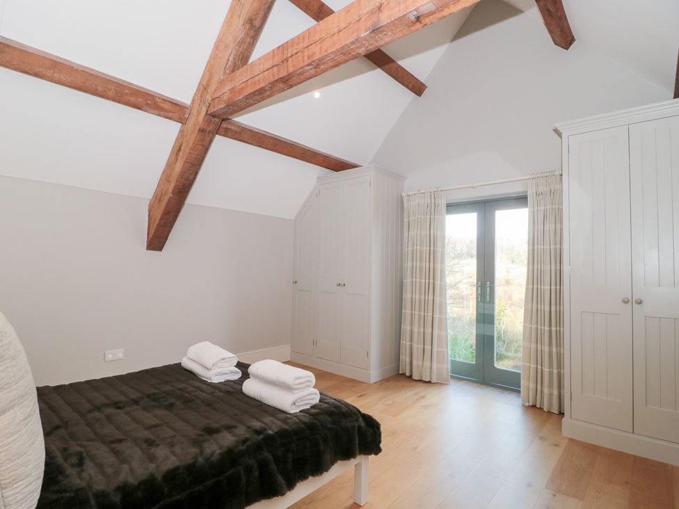 A bedroom with a bed and towels on it at Spring View in Kingscote, Gloucestershire