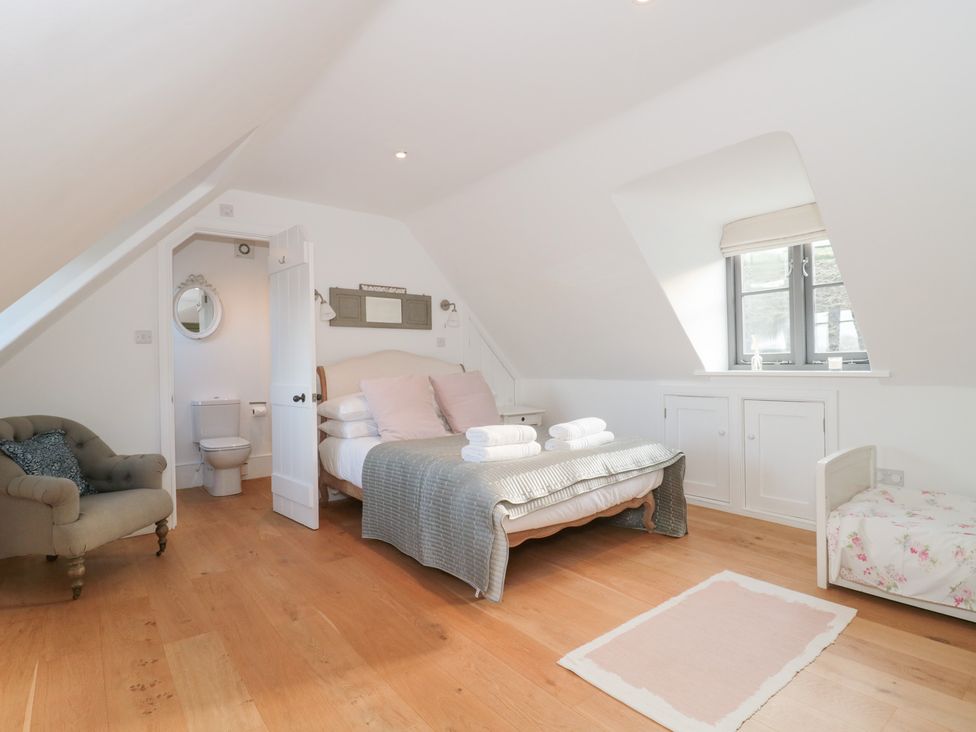 A bedroom with a bed and a chair at Spring View in Kingscote, Gloucestershire