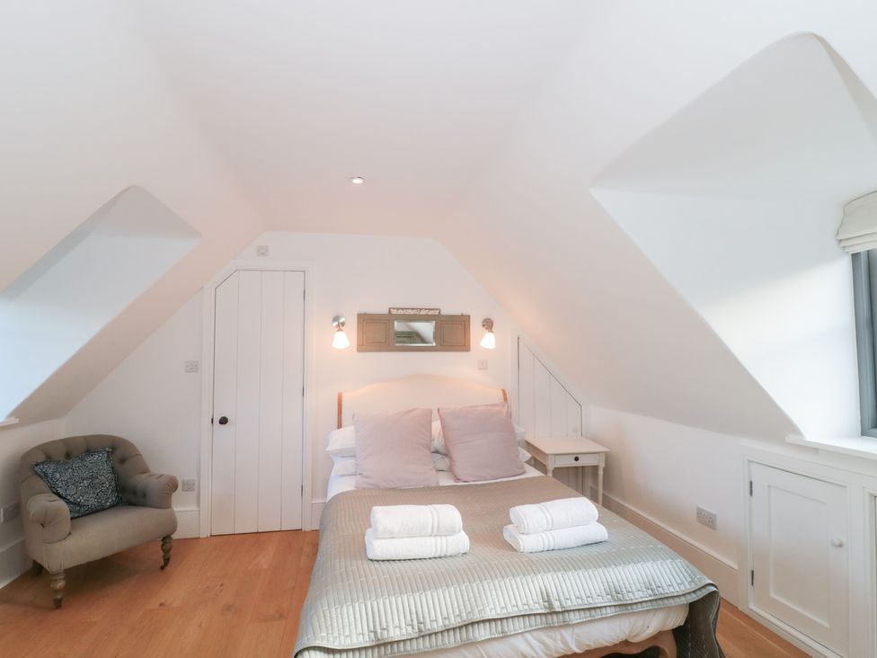 A bedroom with a bed and side table at Spring View in Kingscote, Gloucestershire