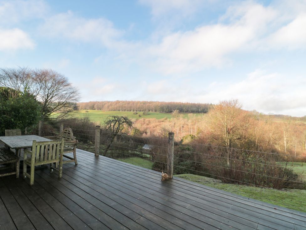 A wooden table and chairs on a deck at Spring View in Kingscote, Gloucestershire