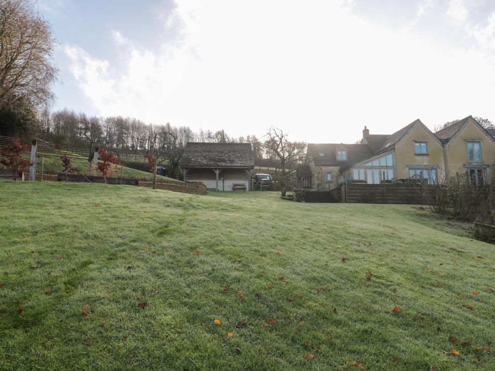 A garden with a house and garage at Spring View in Kingscote, Gloucestershire