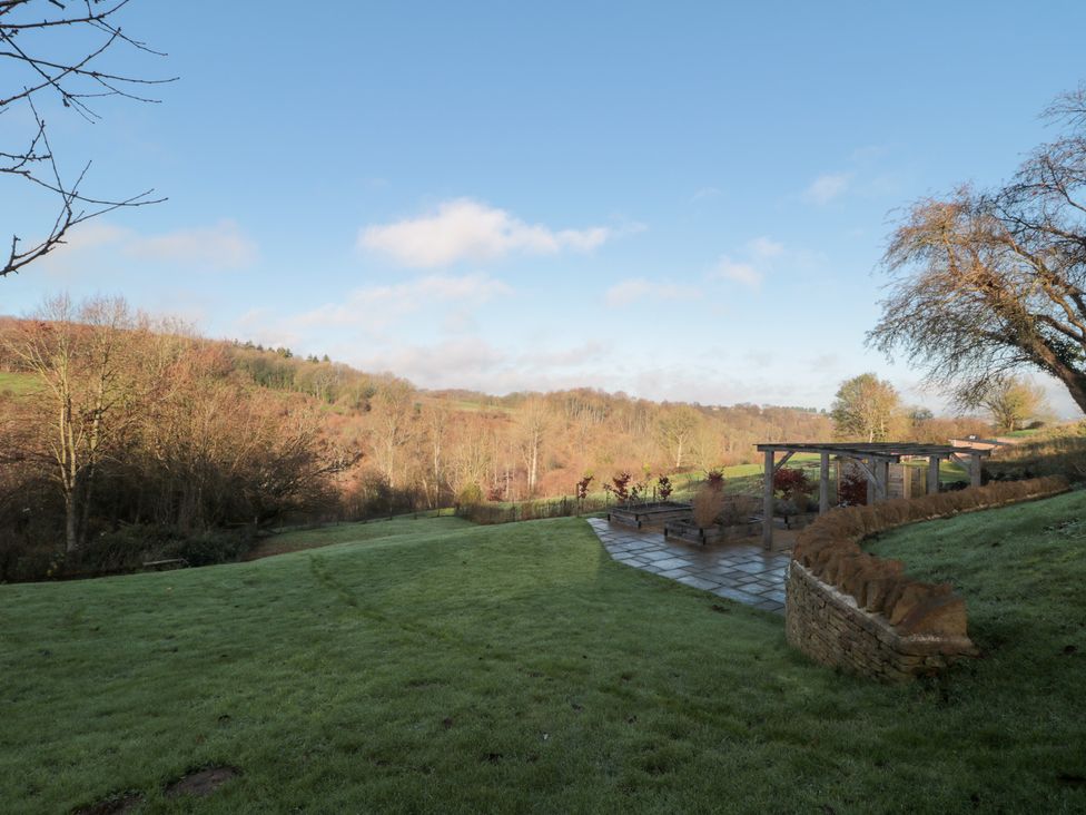 A garden with patio and trees at Spring View in Kingscote, Gloucestershire