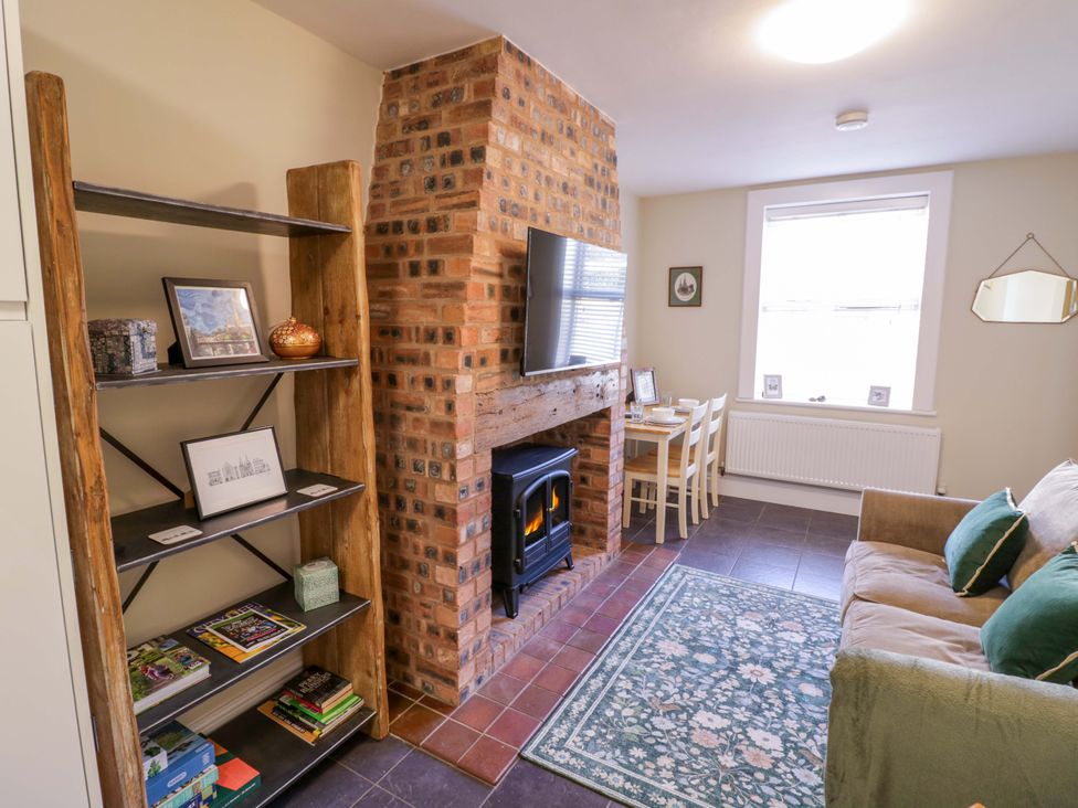 A living room with a television and sofa at Fern Cottage in Lichfield